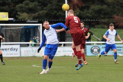 Bognors Chad Field (5) heads clear from Billy Bricknell
