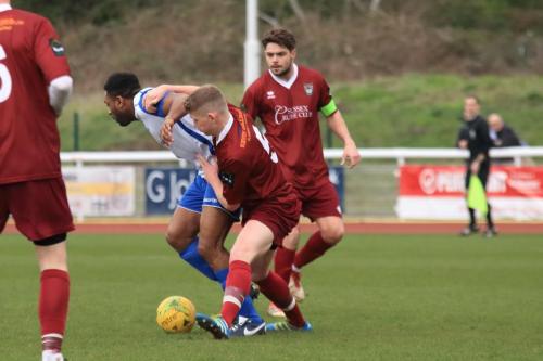 Bognors Chad Field (maroon) challenges Kezie Ibe