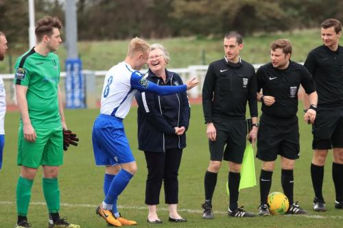 Enfield captain Ryan Blackman introduces mascot Pat Betts to the match officials