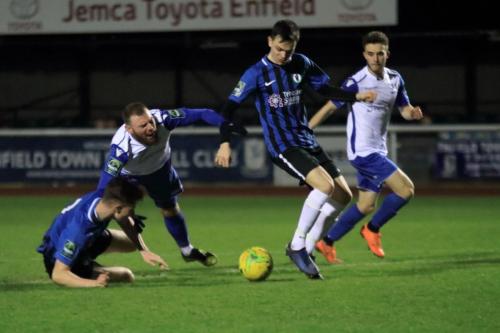 Burgess Hills Josh Tuck (L) brings down Billy Bricknell to conced the penalty from which Bricknell put Enfield 3-0 up