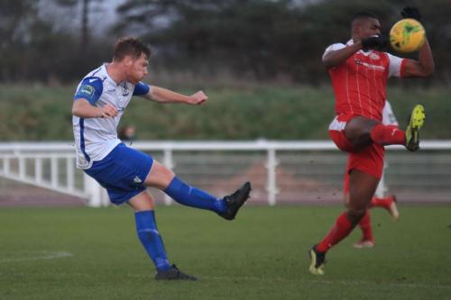 Enfields Marc Weatherstone (L) clears from Emile Acquah