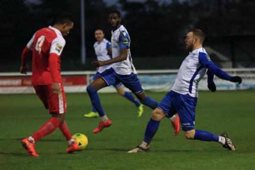 Harlows JJ da Cruz (L) clears from Billy Bricknell