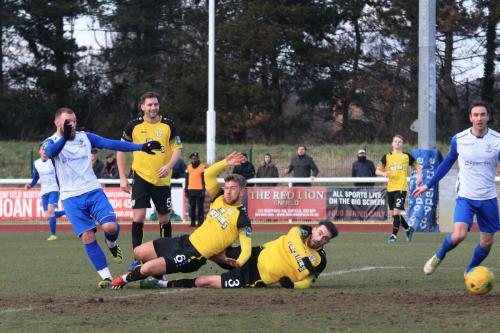 Enfields Billy Bricknell (L) evades the challenges of Ben Swift (6) and Tom Mills but his shot is saved by keeper Louis Wells