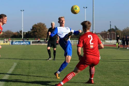 Enfields Ryan Blackman (L) lifts the ball over Fintan Walsh