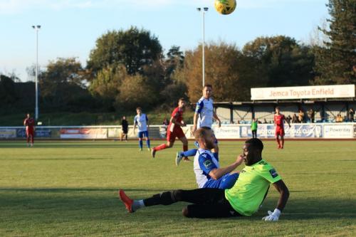 Enfields Sam Hatton almost catches Whitehawk keeper Melvin Minter in possession