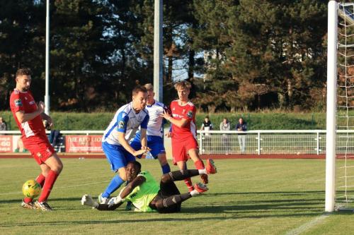 Whitehawk keeper Melvin Minter saves from Liam Hope at the cost of a knee to the jaw