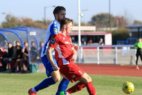 Whitehawks Luke Emberson (red) clears from Remi Sutton