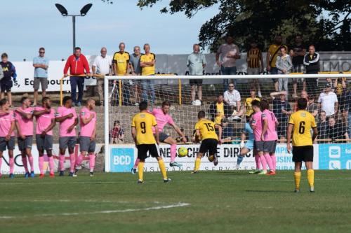 Enfields Remi Sutton clears a late Folkestone free kick