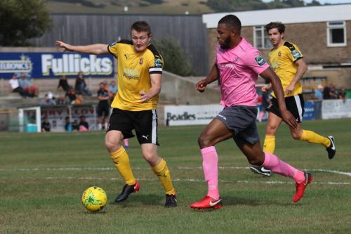 Enfields Taofiq Olomowewe (pink) runs at Callum Davies