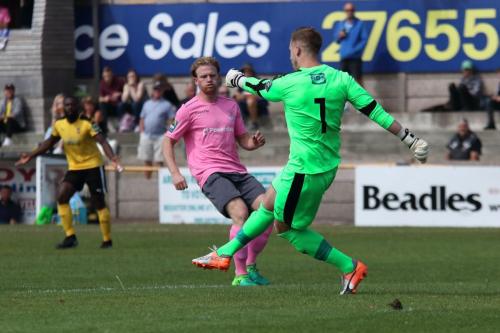 Folkestone keeper Tim Roberts clears from Aaron Greene