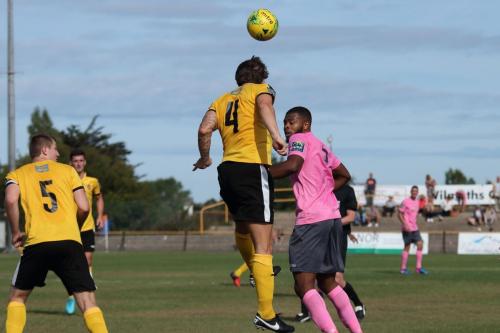 Folkestones Matt Newman (4) heads clear from Taofiq Olomowewe
