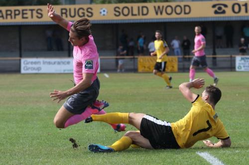 Folkestones Sam Hasler (R) tackles Sam Youngs