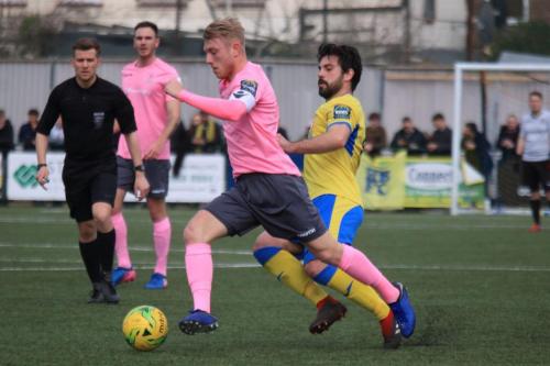 Haringeys Dimitrius Froxylas (yellow) challenges Ryan Blackman