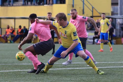 Haringeys Mark Kirby (yellow) grabs a handful of Kezie Ibes shirt