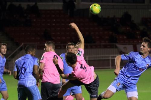 Enfields Ben Jones (pink, R) slices an attempted volley