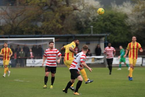 Enfields Kezie Ibe (yellow) challenges Tom Bird