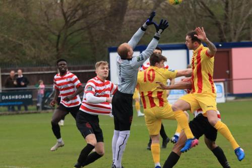 Kingstonian keeper Rob Tolfrey catches under pressure from Enfields Josh Davison (10) and Matt Johnson