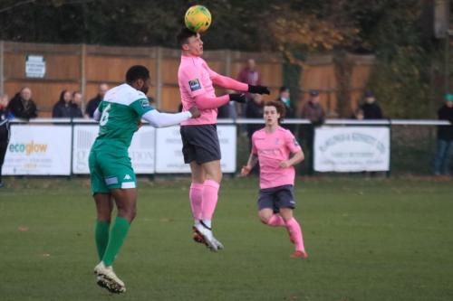 Enfields Brandon Adams (pink) flicks a header past Jerry Nnamani