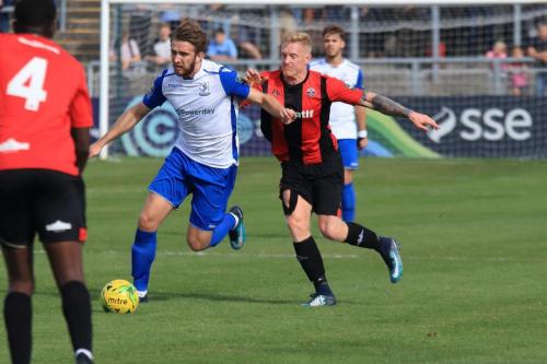 Enfields Remi Sutton (White) challenged by Luke Blewden