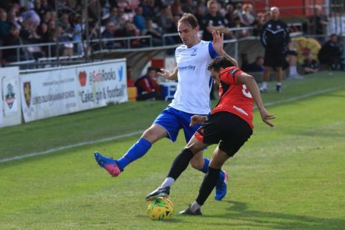 Lewes Leon Redwood (R) clears from Matt Johnson