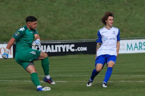 Lewes keeper Lewis Carey clears from Sam Chaney