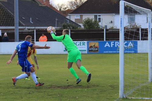 Lowestoft keeper Elvijs Putnins collects ahead of his captain Rossi Jarvis (blue) and Enfields Billy Bricknell