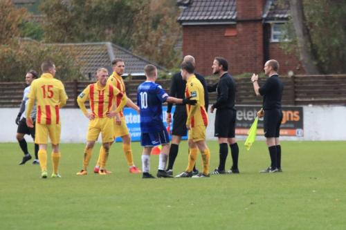 The match officials confer after a brief skirmish between the two teams