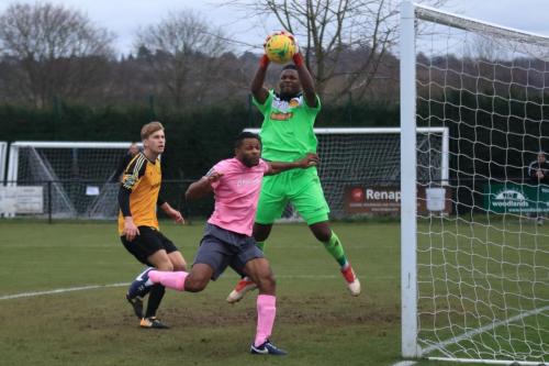 Merstham keeper Amadou Tangara collects ahead of Enfields Kezie Ibe