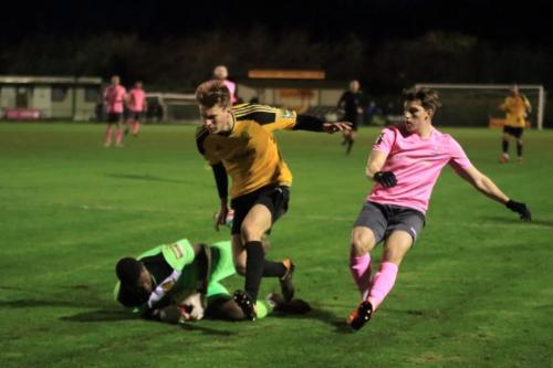 Merstham keeper Amadou Tangara collects ahed of teammate Oliver Cook and Enfields Josh Davison (R)