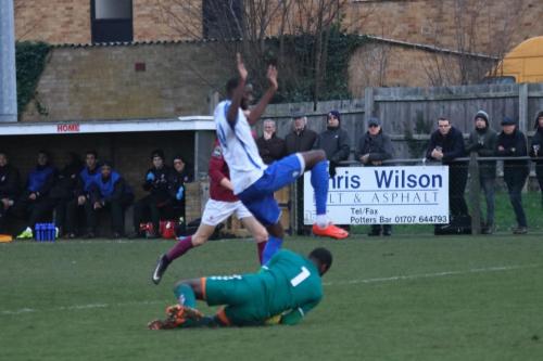 Potters Bar keeper Berkley Laurencin saves at the feet of Muhammadu Faal