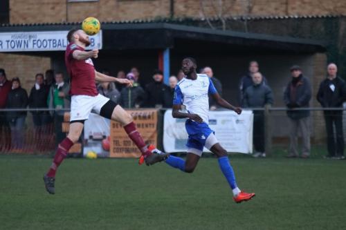 Potters Bars James Budden (L) heads clear from Muhammadu Faal