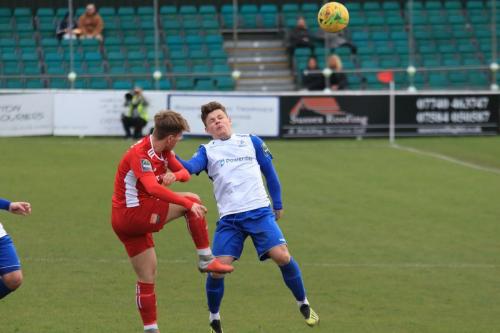 Whitehawks Fintan Walsh (red) clears from Jay Porter