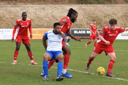 Whitehawks John Paul Kissock (R) clears as Yannis Ambroisine holds off Kezie Ibe