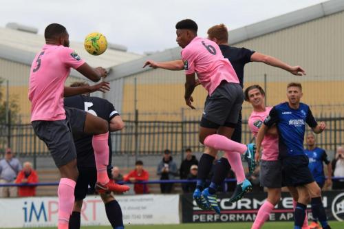 Enfields Taofiq Olomowewe (L) and Rian McLean challenge at a corner