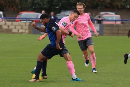 Wingates Luke Ifil (blue) challenges Brandon Adams