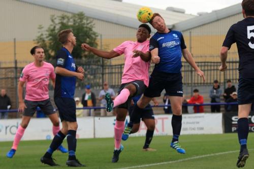 Wingates Marc Weatherstone (blue) wins a header against Rian McLean