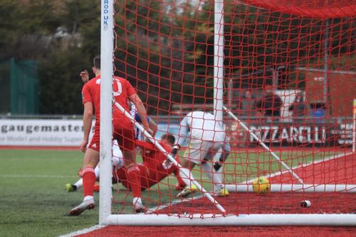 Billy Bricknell (obscured by the red-shirted defenders) puts Enfield ahead from very close range