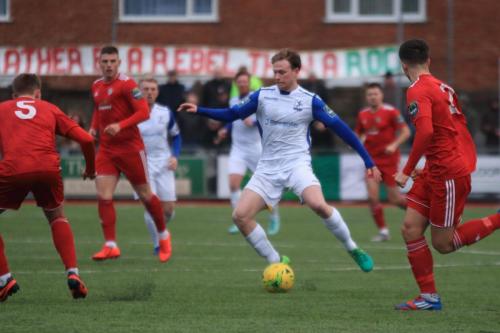 Enfields Aaron Greene runs at Joel Colbran (5) and Billy Barker
