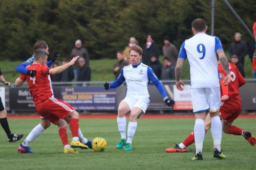 Worthings Darren Budd (red, L) challenges Sam Youngs and Aaron Greene (centre)