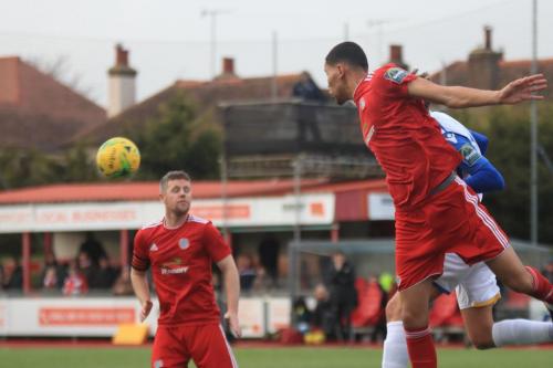 Worthings Jalen Jones (red, L) heads clear