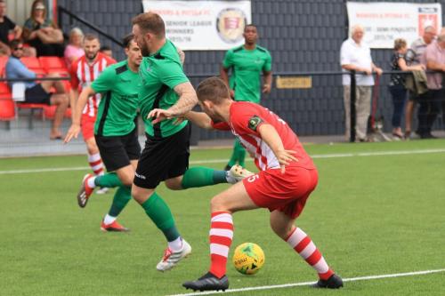 Enfields Billy Bricknell (green) tries to backheel the ball past Kenzer Lee