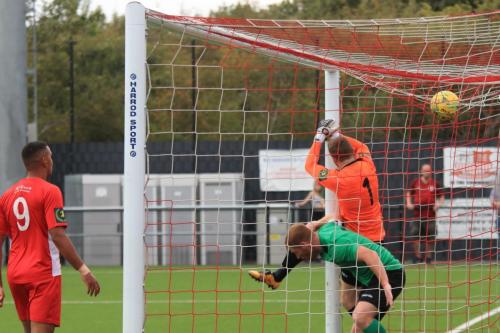 Enfields Marc Weatherstone (green) and Bowers keeper Callum Chafer end up in the goal as the ball drops onto the top of the net