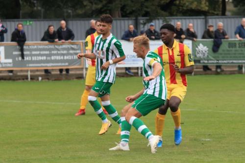 Chichester captain Connor Cody (green,R) beats Charles Brown to the loose ball after Steve Mowthorpes save from Ken Charles