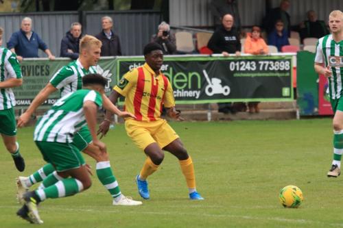 Enfields Charles Brown (yellow) lays the ball off under challenge from Connor Cody