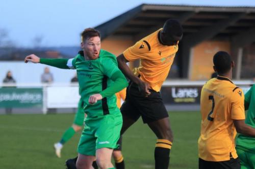 Cheshunts Mo Camara (centre) heads clear from Marc Weatherstonex