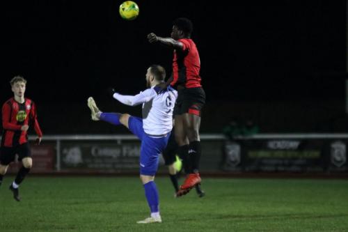 Lewes Christian Frimpong (R) heads clear from Billy Bricknell