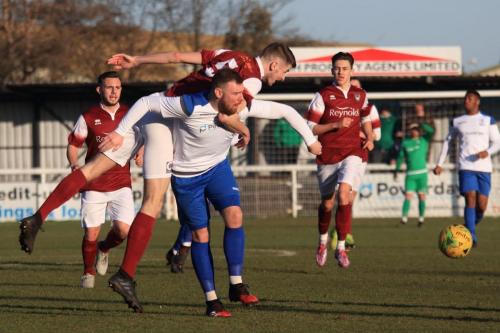 Bognors Matt Casey (maroon) wins a header against Billy Bricknell