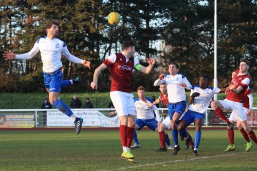 Enfields Josh Urquhart (L) heads the ball across goal