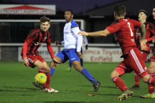 Enfields Jon Muleba plays the ball forward past Jake Turner (L)