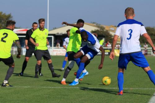 Potters Bars Ryan Young (yellow, R) challenges Muhammadu Faal
